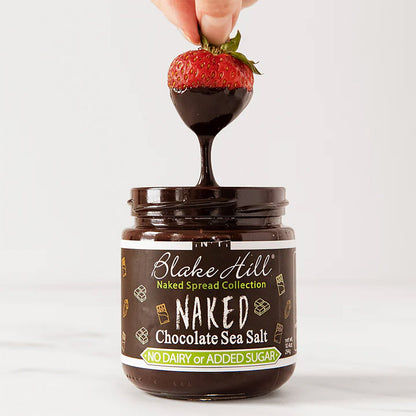 Jar of Blake Hill Naked Chocolate Sea Salt spread with a strawberry being dipped into it.