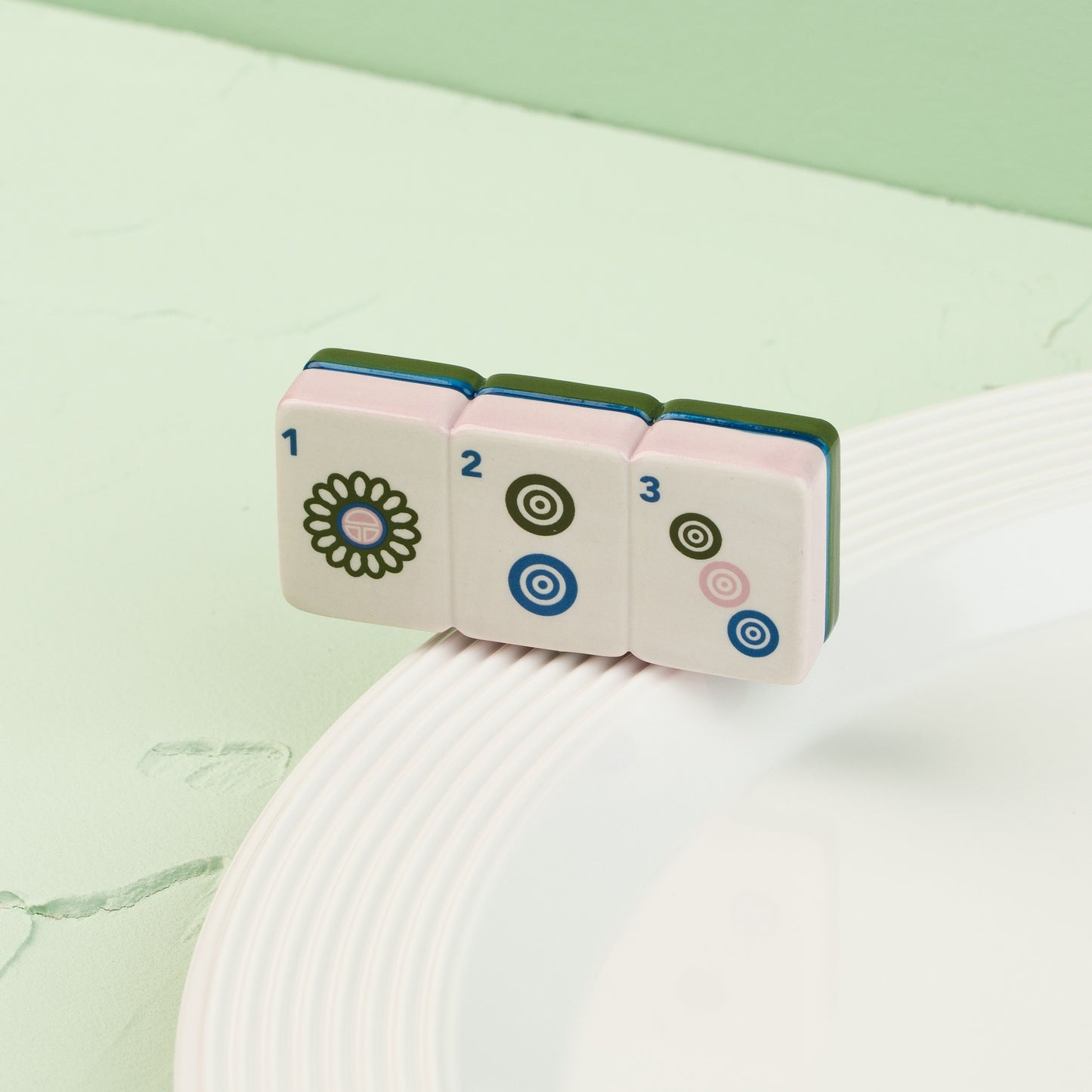 Set of colorful dice with floral and circular designs on a white surface with a green background